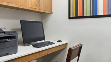 A workspace with a computer, printer, and a chair.
