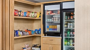 A snack and beverage refrigerator stocked with various snacks and drinks. - Holiday Inn Express & Suites Greenville - Downtown by IHG (Greenville)