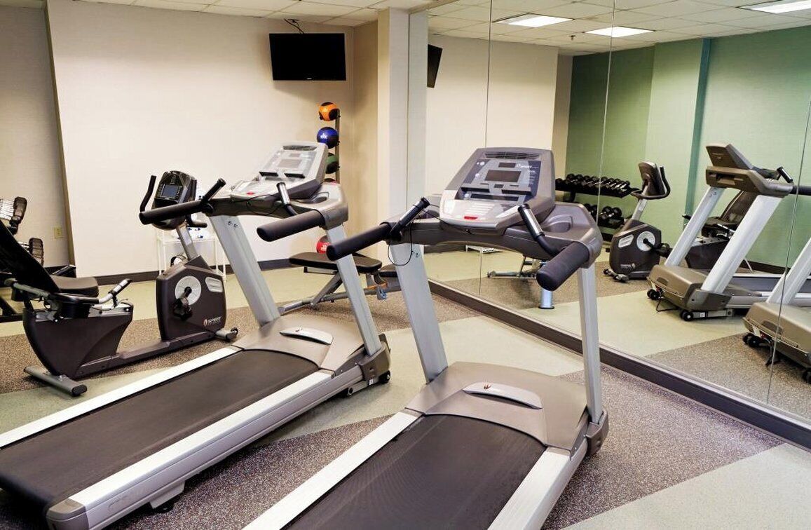 A gym with treadmills, exercise bikes, and weights.