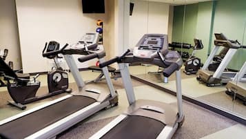 A gym with treadmills, exercise bikes, and weights.