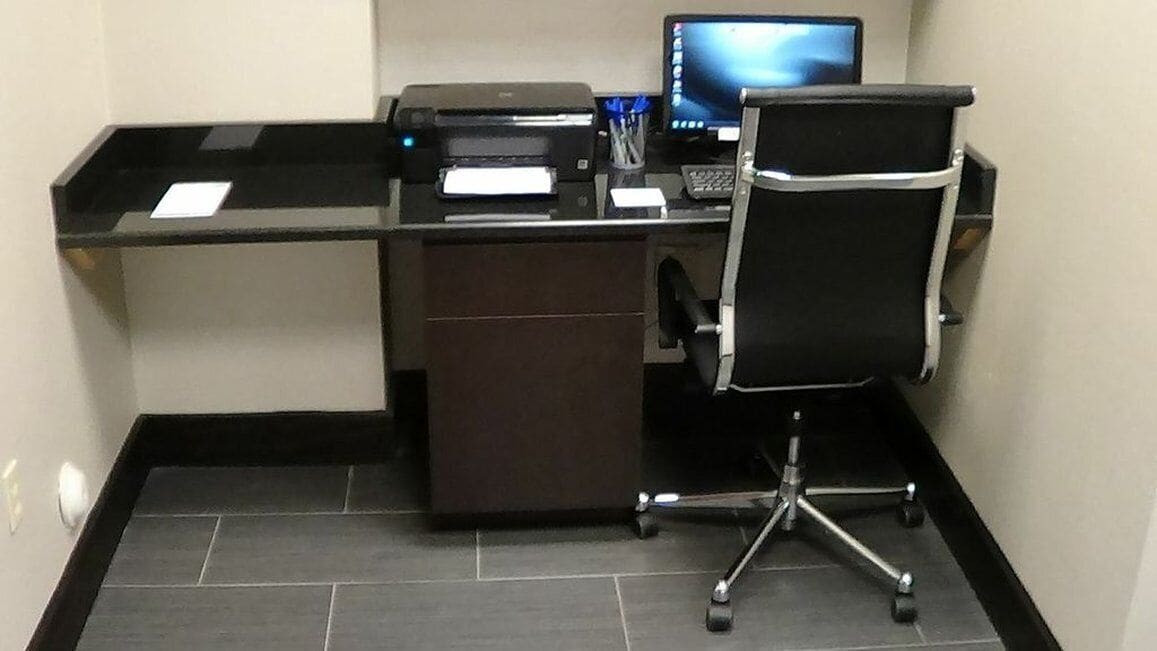 Un bureau moderne, équipé d’un ordinateur, d  ’une imprimante et d’une chaise.