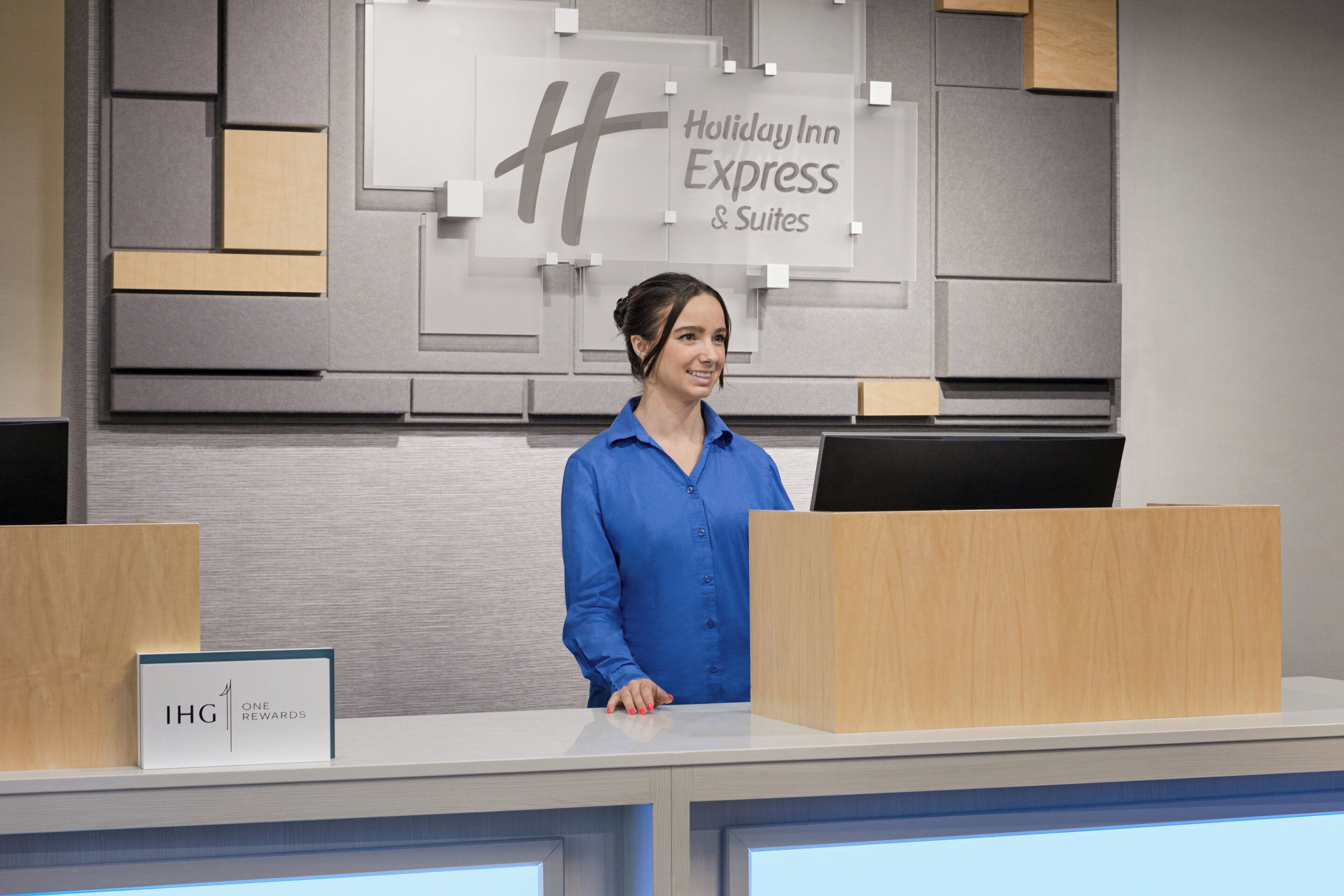 A hotel reception desk with a sign indicating Holiday Inn Express & Suites.