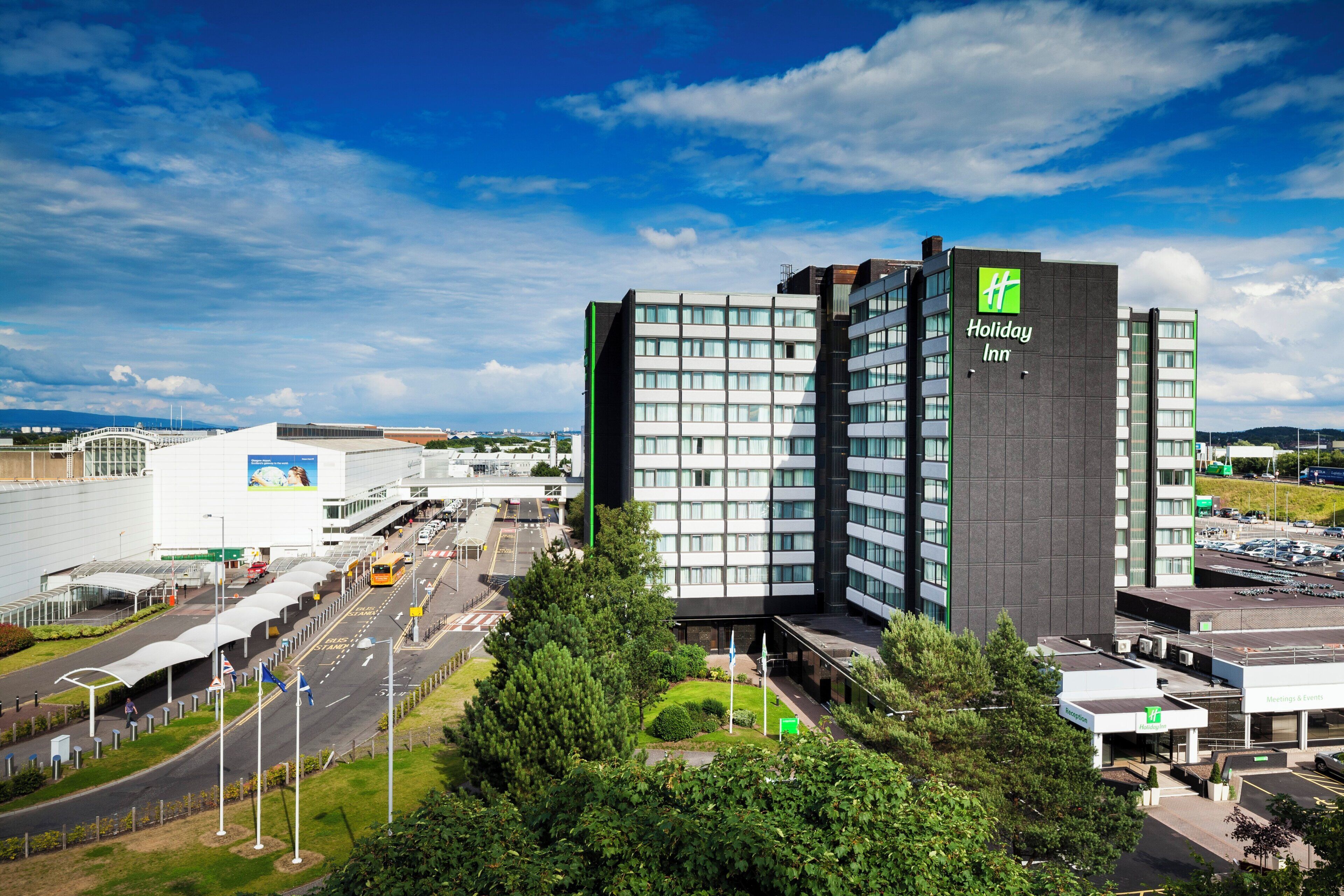A Holiday Inn hotel with a modern design, featuring a prominent green logo on the facade.