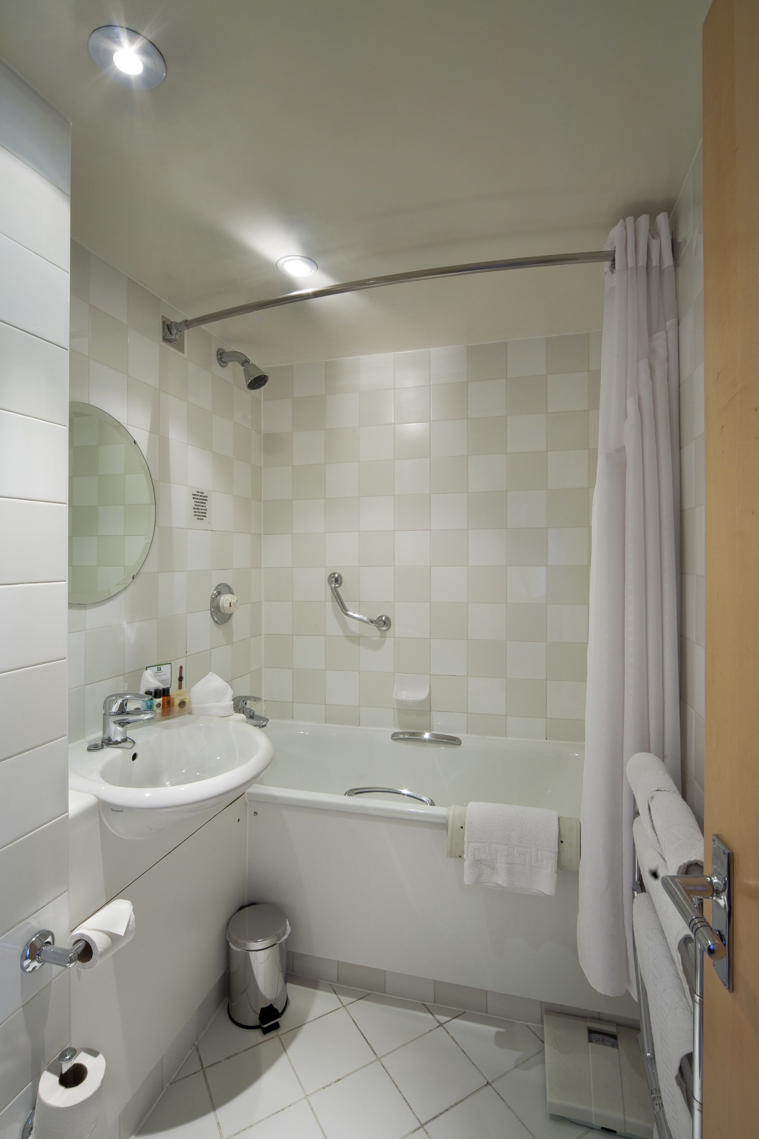 A modern bathroom with a white sink, toilet, and bathtub.