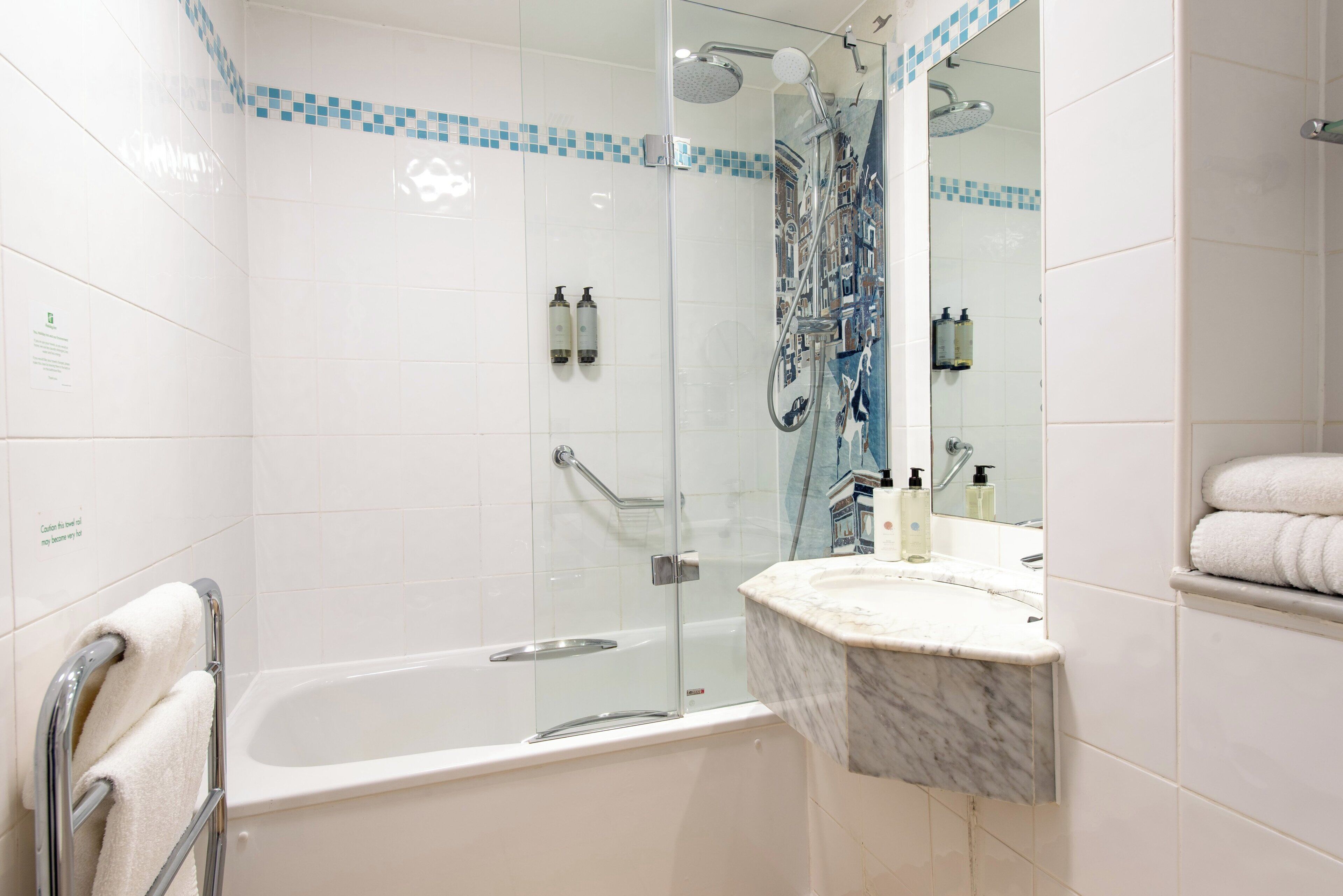 Ein modernes Badezimmer mit einer Duschkabine, einer Badewanne und einem Marmorwaschbecken.