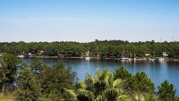 A lake with boats, surrounded by dense trees and a clear sky.