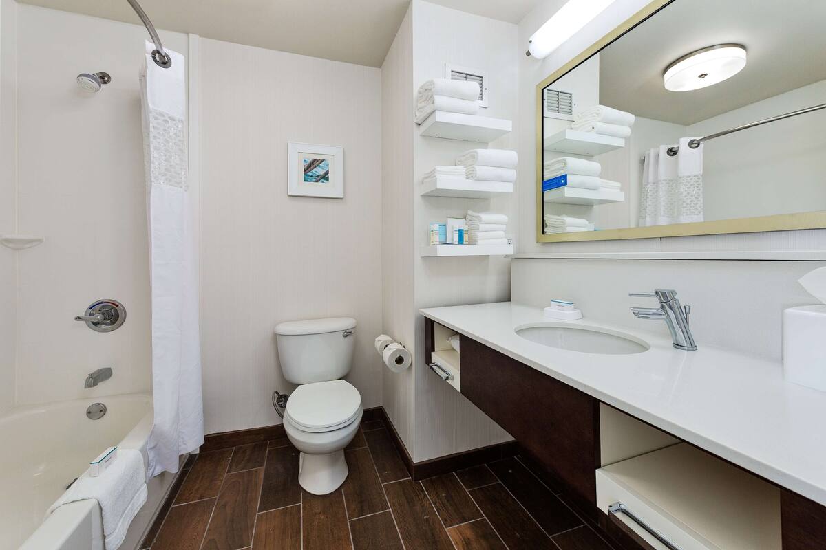 A modern bathroom with a bathtub, toilet, and sink.
