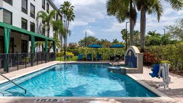 Alberca al aire libre, sombrillas en la alberca y camastros