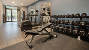 A gym with treadmills, a bench press, and a rack of dumbbells. - Hampton Inn West Palm Beach Florida Turnpike (West Palm Beach)