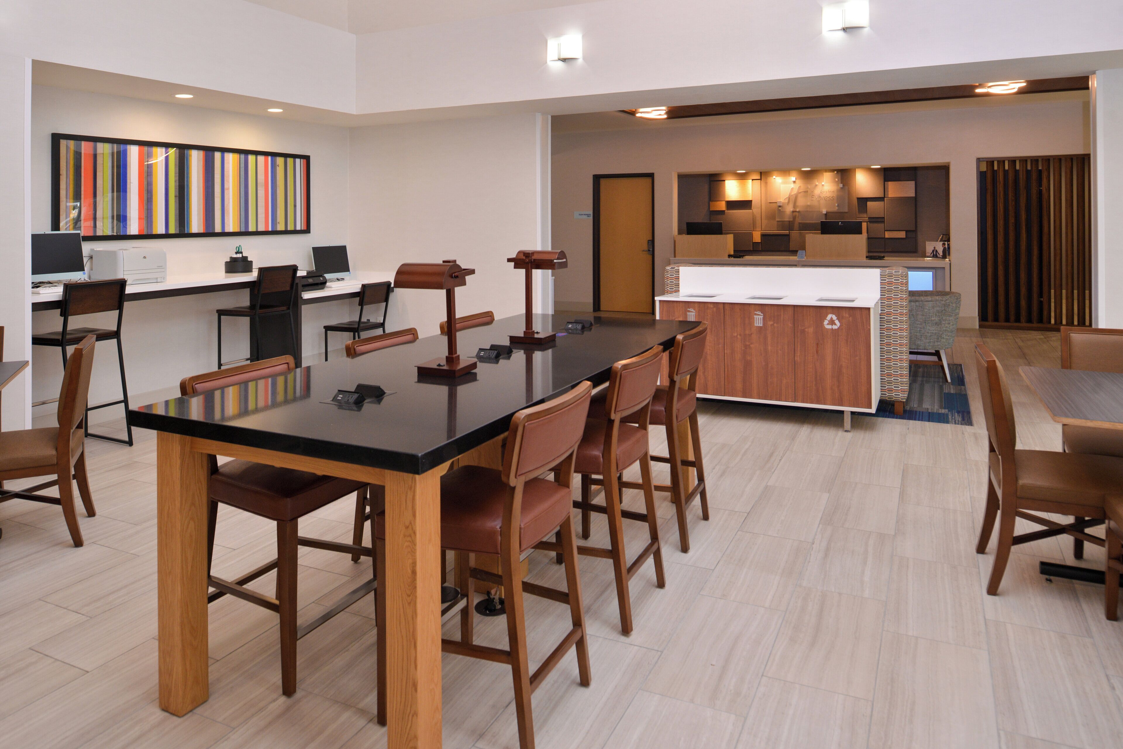 A modern kitchen with a central island, bar stools, and a dining table with chairs.