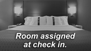 A hotel room with a bed, two bedside tables, and wall-mounted lamps. - Holiday Inn Express Stockton Southeast by IHG (Stockton)