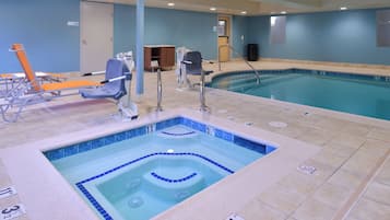Una piscina con hidromasaje, sillas de descanso y un vestuario.