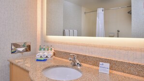 A bathroom with a granite countertop, a sink, a mirror, and a towel rack. - Holiday Inn Express Stockton Southeast by IHG (Stockton)