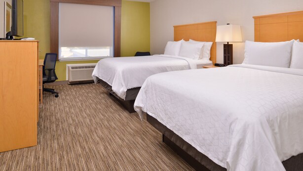 A hotel room with two beds, a desk, a chair, a TV, and a window with blinds. - Holiday Inn Express Stockton Southeast by IHG (Stockton)