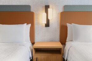 A hotel room with two beds, a nightstand, and a wall-mounted light fixture. - Hampton Inn & Suites by Hilton Langley-Surrey (Surrey)