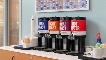 A coffee station with four dispensers labeled DARK ROAST, LIGHT ROAST, DECAF ROAST, and HOT WATER.