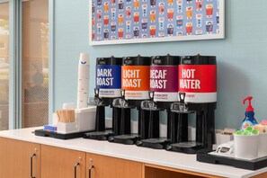 A coffee station with four dispensers labeled DARK ROAST, LIGHT ROAST, DECAF ROAST, and HOT WATER. - Hampton Inn & Suites by Hilton Langley-Surrey (Surrey)