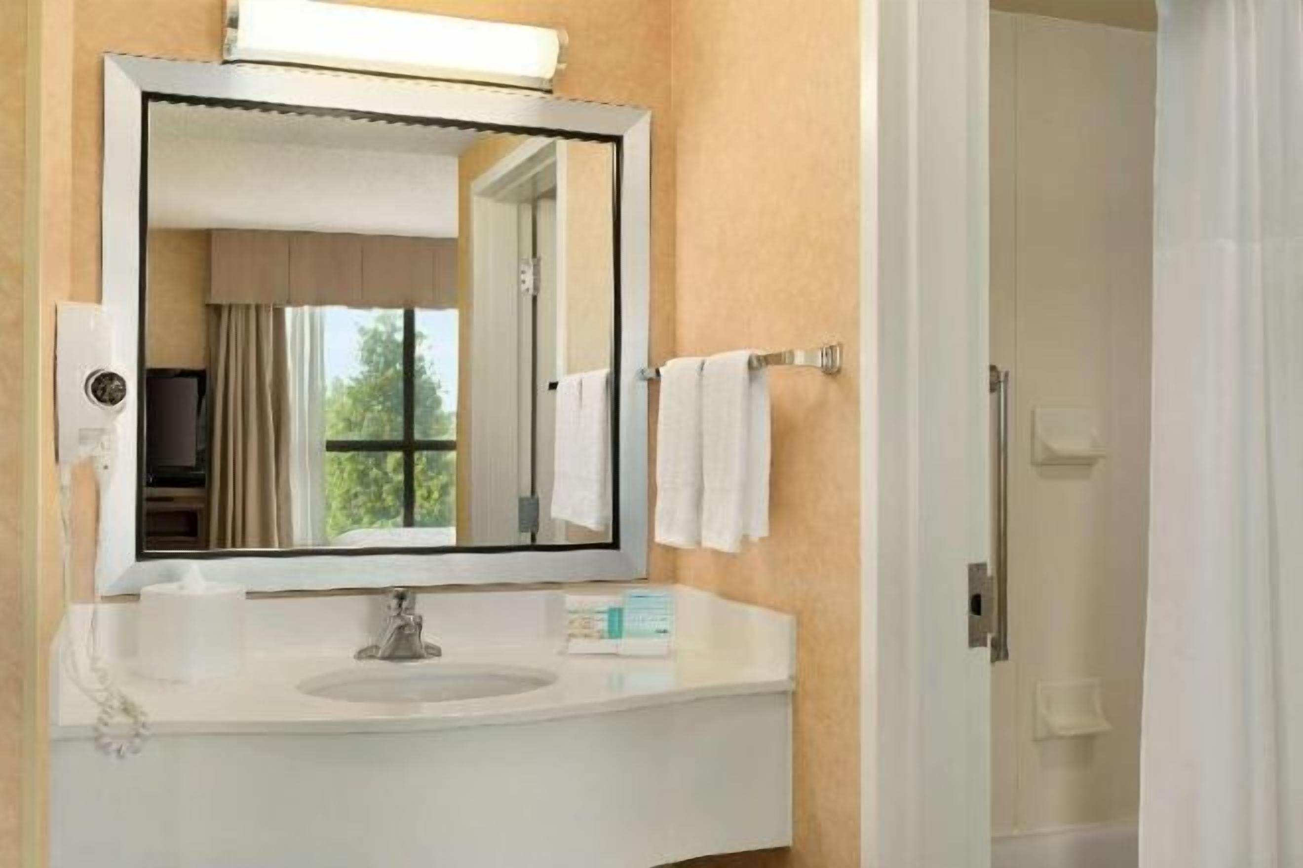 Badkamer | Een bad/douchecombinatie, een haardroger, handdoeken, zeep