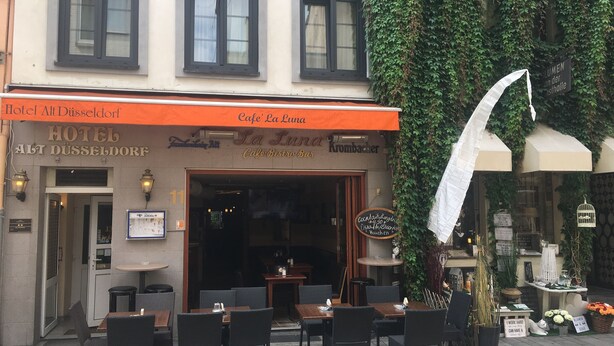 A café with outdoor seating, a sign for Café La Luna, and a partially visible entrance to Hotel Alt Düsseldorf. - AltDüsseldorf (Düsseldorf)