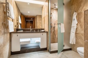 A modern bathroom with a glass-enclosed shower, a vanity with a mirror, and a toilet.
