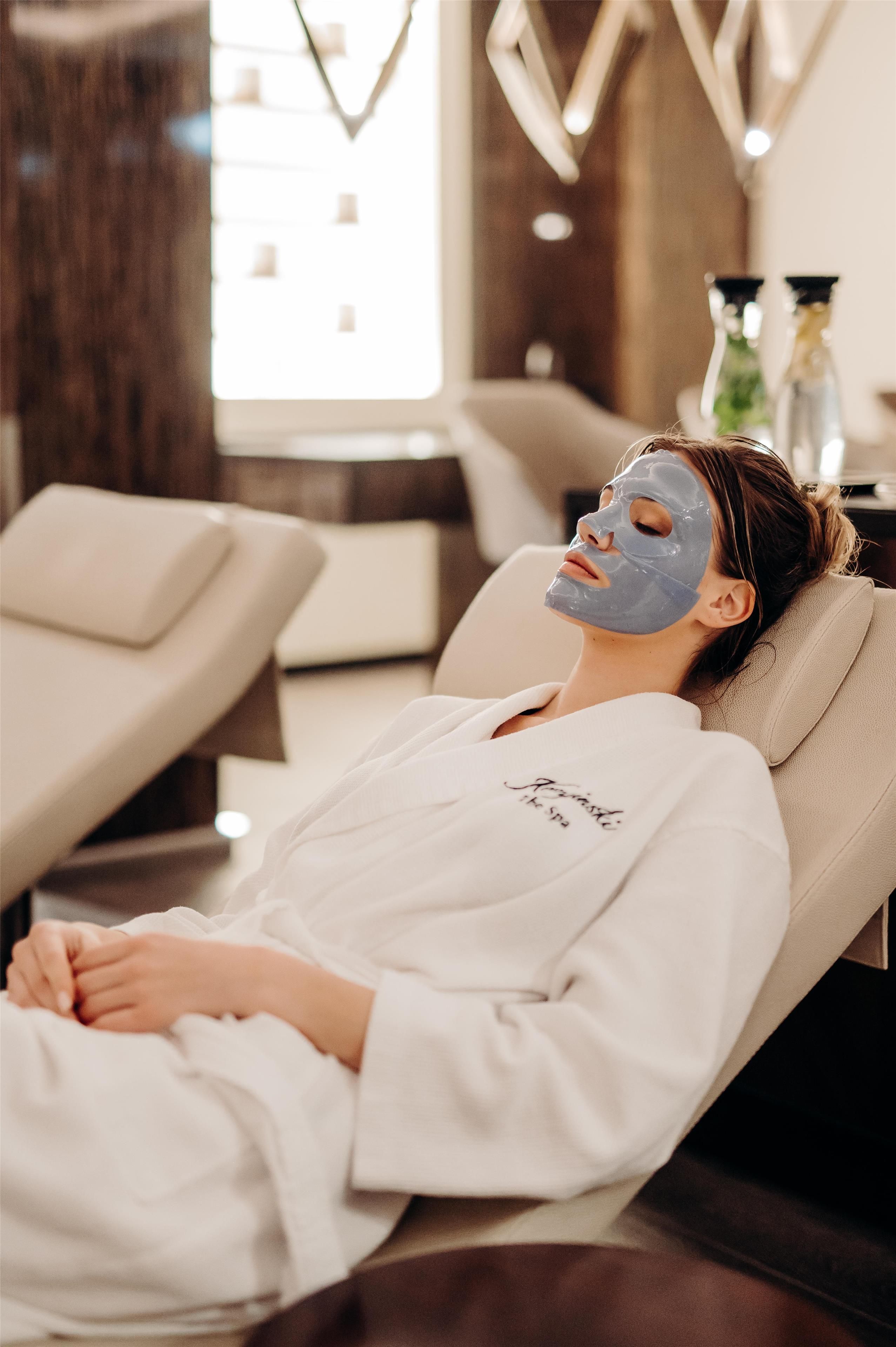A person lying on a massage chair in a spa setting.