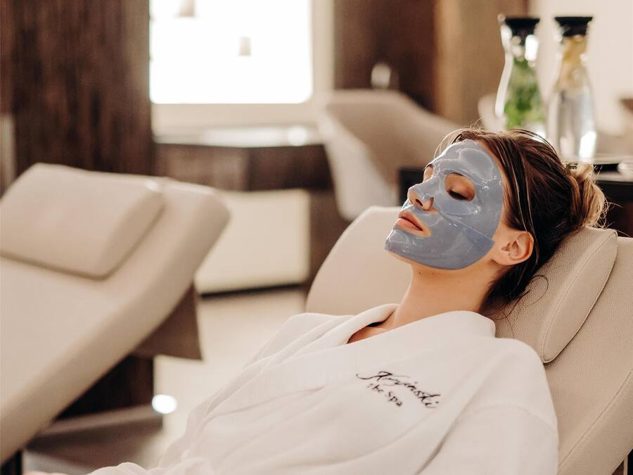 A person lying on a massage chair in a spa setting.