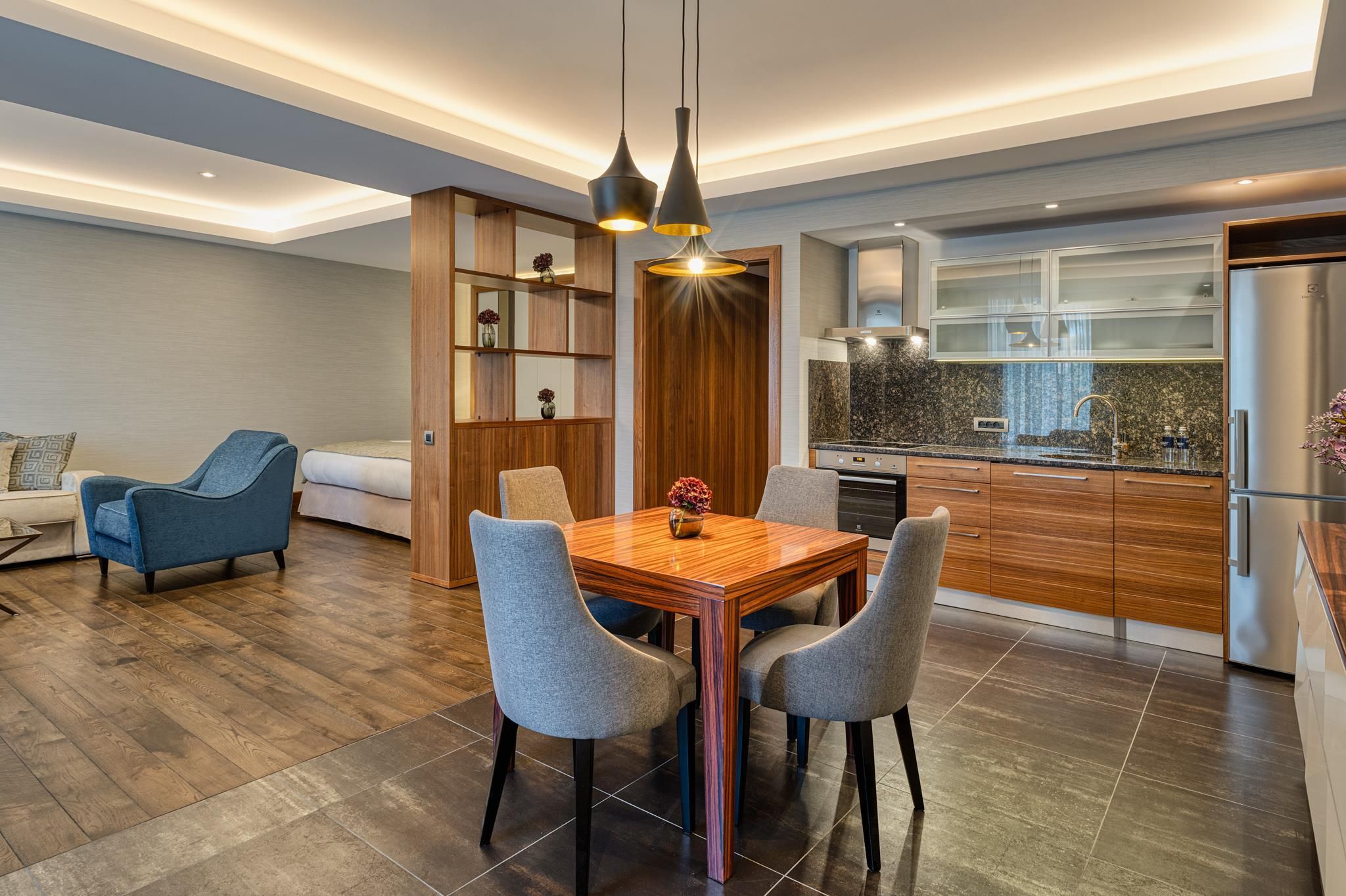 Una cocina moderna con comedor, armarios de madera y horno empotrado.