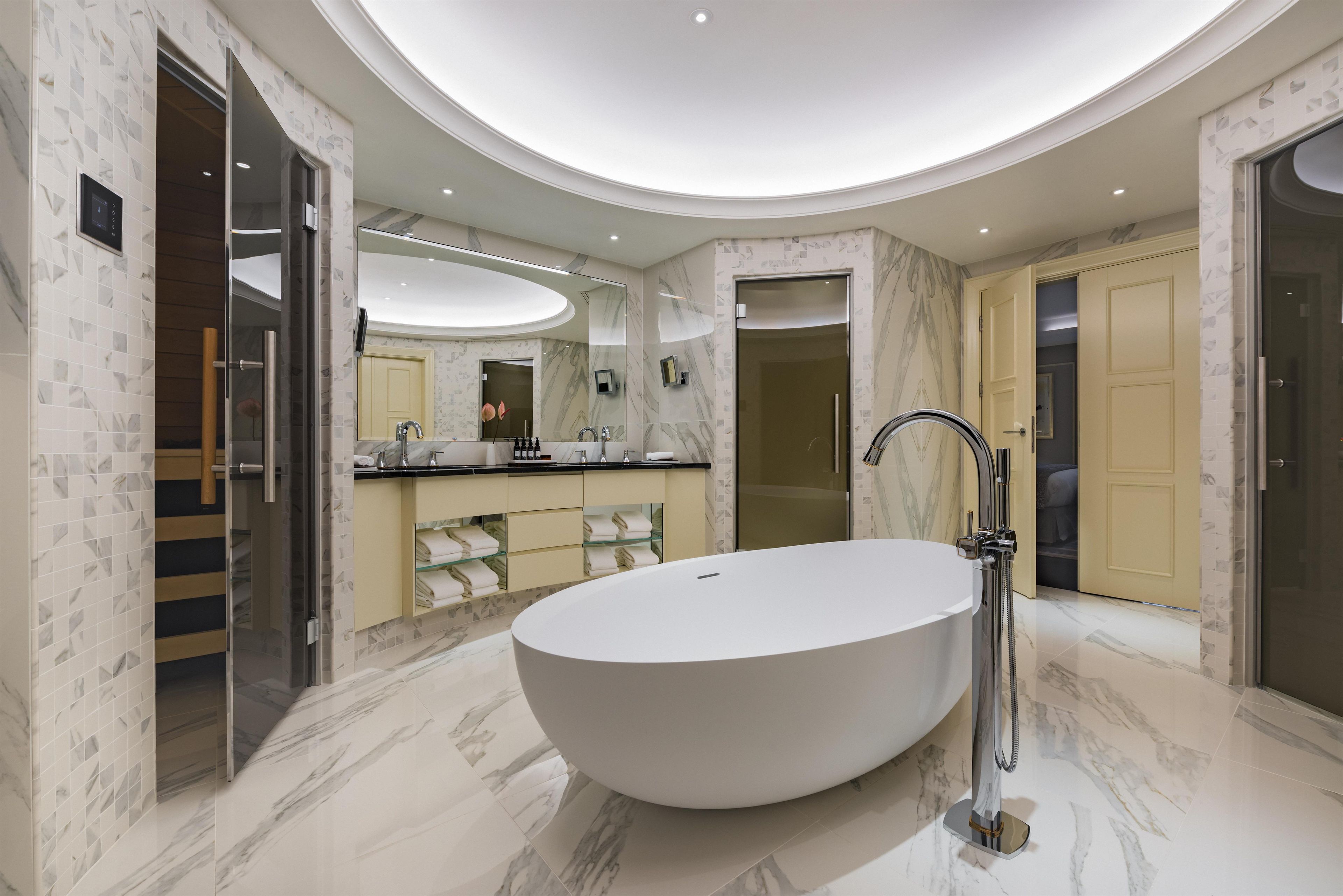 A modern bathroom with a freestanding bathtub, a vanity with a mirror, and a shower area.