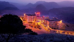 A hotel complex with multiple buildings, a central entrance, and a parking area, surrounded by mountainous terrain. - Petra Marriott Hotel (Wadi Musa)