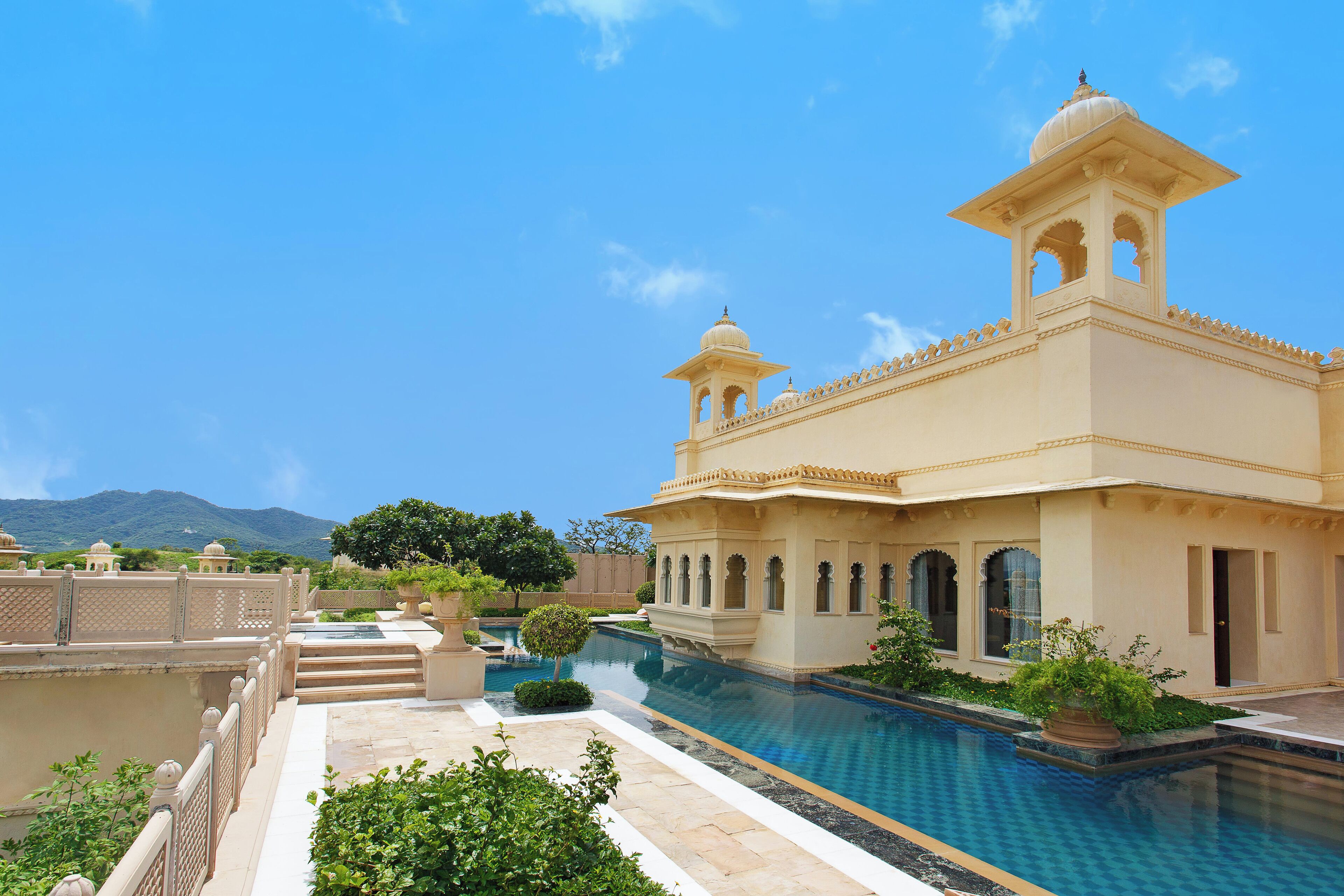 A traditional building with a pool, steps, and a clear sky.