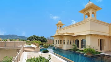 A traditional building with a pool, steps, and a clear sky.