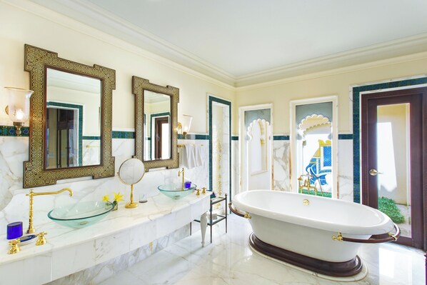 A luxurious bathroom with a large freestanding bathtub, a glass-enclosed sink, and multiple mirrors with ornate frames. - The Oberoi Udaivilas, Udaipur (Udaipur)