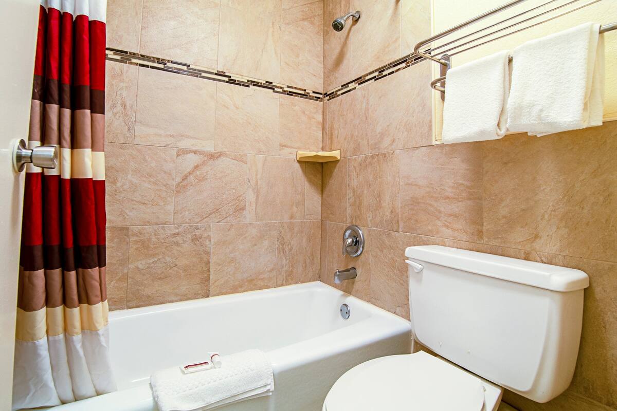 Ein Badezimmer mit Badewanne, Toilette und Handtuchhalter.