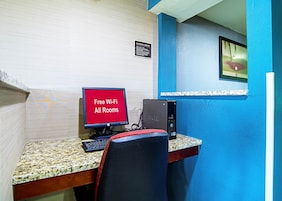 Escritorio con una computadora de escritorio Dell y un monitor que muestra 'Wi-Fi gratuito en todas las habitaciones'.