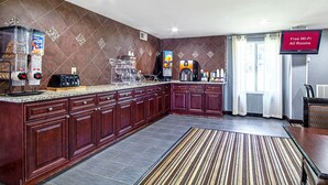 A modern kitchen with a built-in coffee machine, a refrigerator, and a sign indicating free Wi-Fi in all rooms. - Red Roof Inn & Suites Greenwood, SC (Greenwood)