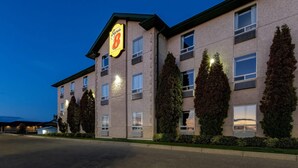 Un hotel con un evidente cartello 'Super 8', diverse finestre e una facciata ben illuminata.