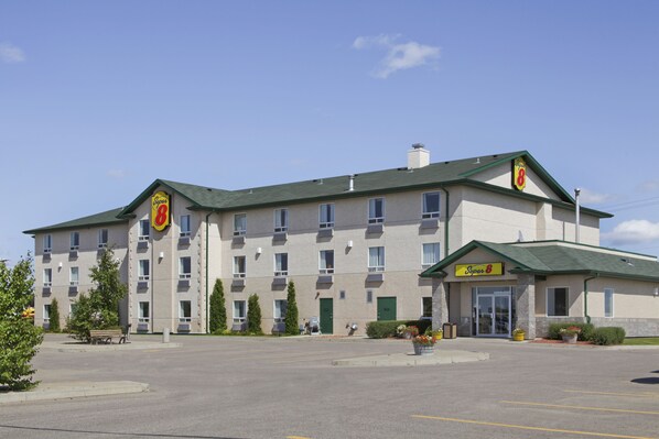 Un hôtel à plusieurs étages doté d’un toit végétalisé et d’une enseigne indiquant qu’il s’agit d’un hôtel Super 8.