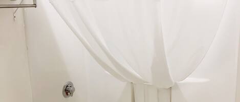 A bathroom with a white bathtub, toilet, and a towel rack.