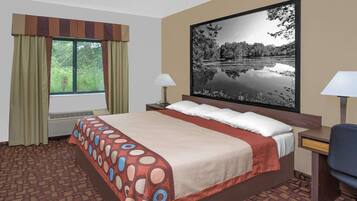 A hotel room with a large bed, a desk with a chair, a window with curtains, a wall-mounted flat-screen TV, and a radiator.