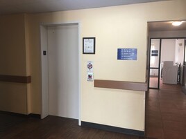 Pasillo de hotel con indicaciones hacia habitaciones, piscina, spa, centro de negocios, baños y máquinas expendedoras.