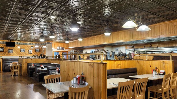 A restaurant with wooden booths, tables, and a bar area. - Super 8 by Wyndham Fallon (Fallon)