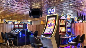 A casino area with slot machines, bar stools, and a wooden ceiling. - Super 8 by Wyndham Fallon (Fallon)