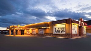 A building with a marquee sign, framed pictures, and a parking lot. - Super 8 by Wyndham Fallon (Fallon)