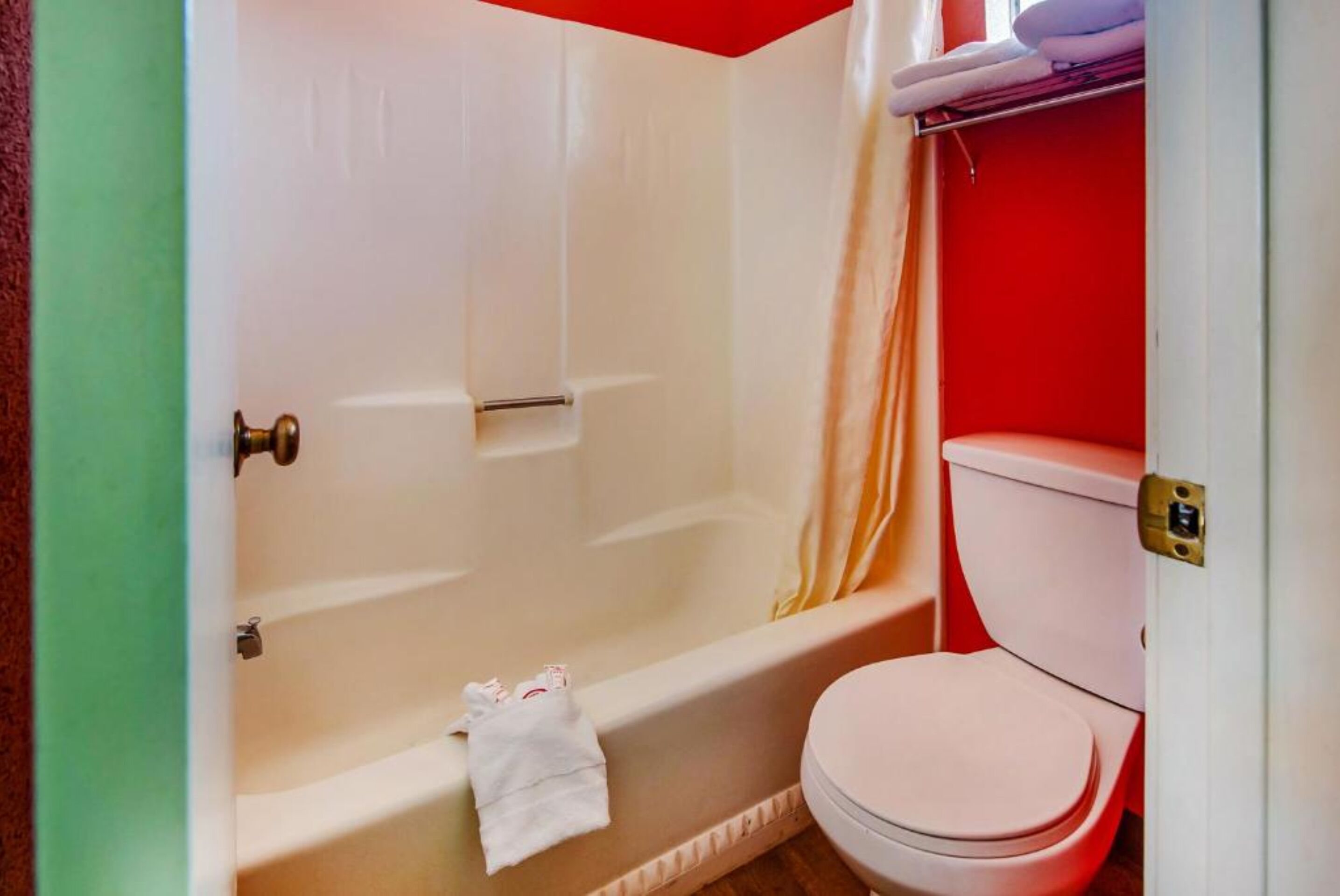 A bathroom with a bathtub, toilet, and a towel rack.