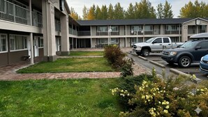 A multi-story motel with a central courtyard, parking area, and a row of rooms with balconies. - Park Inn by Radisson, Quesnel (Quesnel)