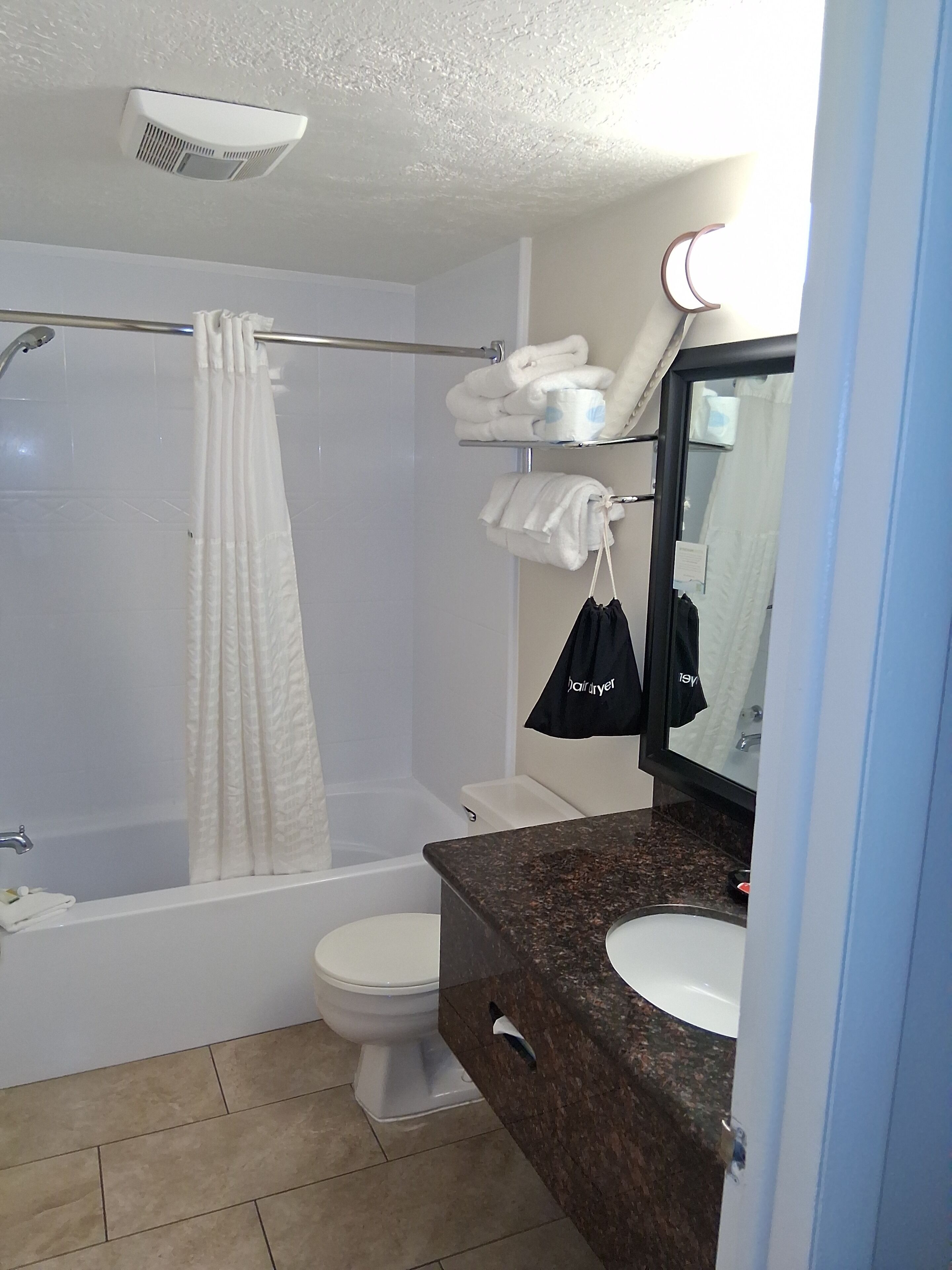A bathroom with a bathtub, toilet, and sink.