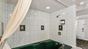 A bathroom with a green bathtub, white tiled walls, and a shower area. - Rose Garden Inn - San Jose Airport (San Jose)