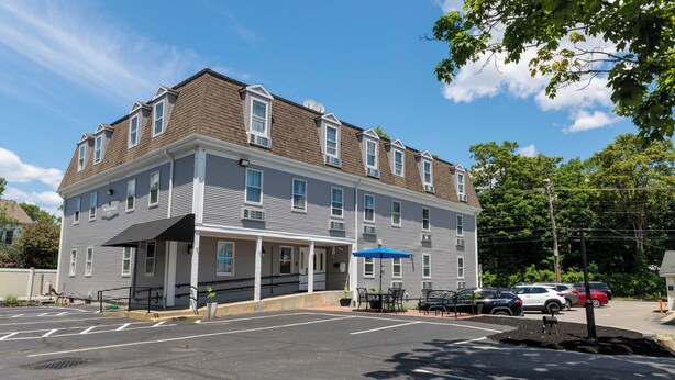 A two-story building with a covered patio area and a parking lot.
