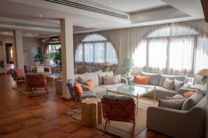 Amplia sala de estar con un sofá grande, una mesa de centro y una chimenea.