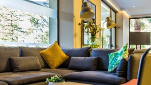 En moderne stue med en modulsofa, et sofabord og en potteplante.
